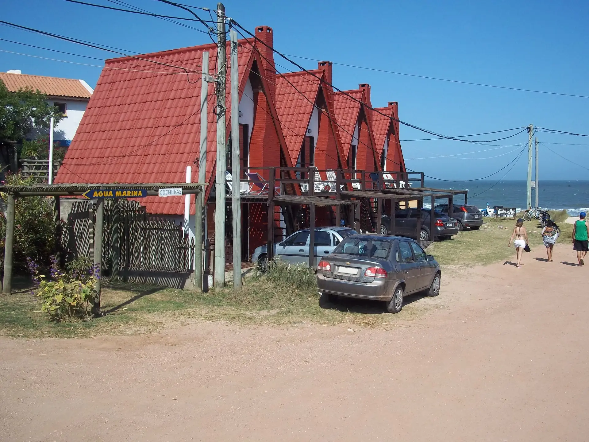 Cabañas de techo rojo a dos aguas frente al mar en Punta del Diablo